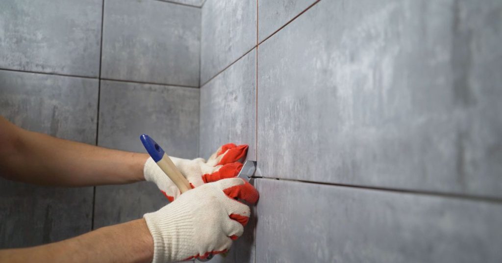 person cleaning grout lines with a brush to keep them looking new and fresh.