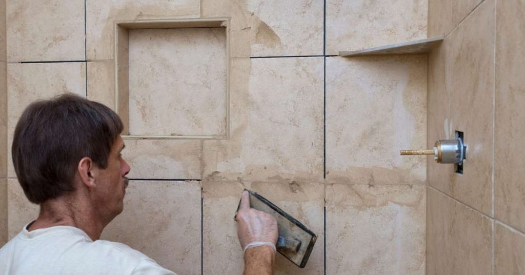 Applying grout sealer to bathroom tiles
